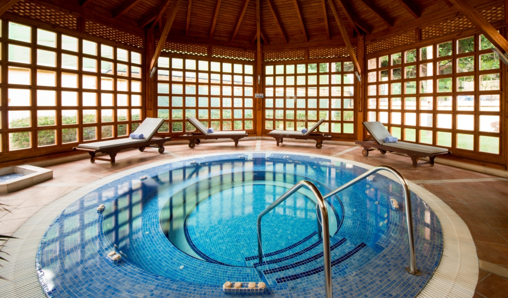 Binnenjacuzzi omringd door ligstoelen in de spa van Tenerife.