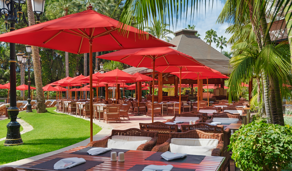 Terras met rode parasols en tafels in een openluchtrestaurant op Tenerife.