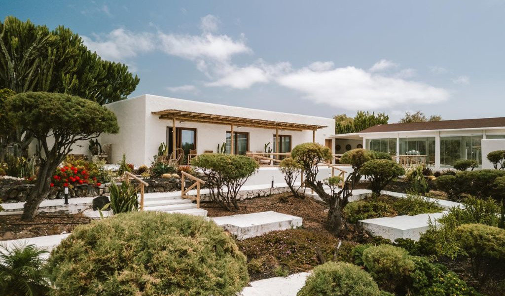 Wit huis met tuin en terras op Tenerife onder een blauwe lucht.