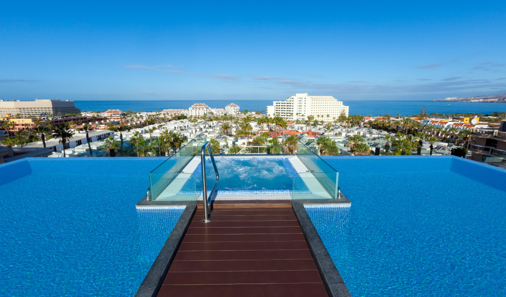 Infinity zwembad met uitzicht op zee en gebouwen aan de Costa Adeje, Tenerife.