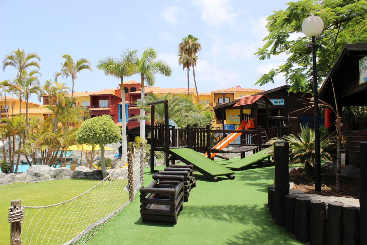 Speeltuin met glijbaan en palmbomen in het resort van Tenerife.