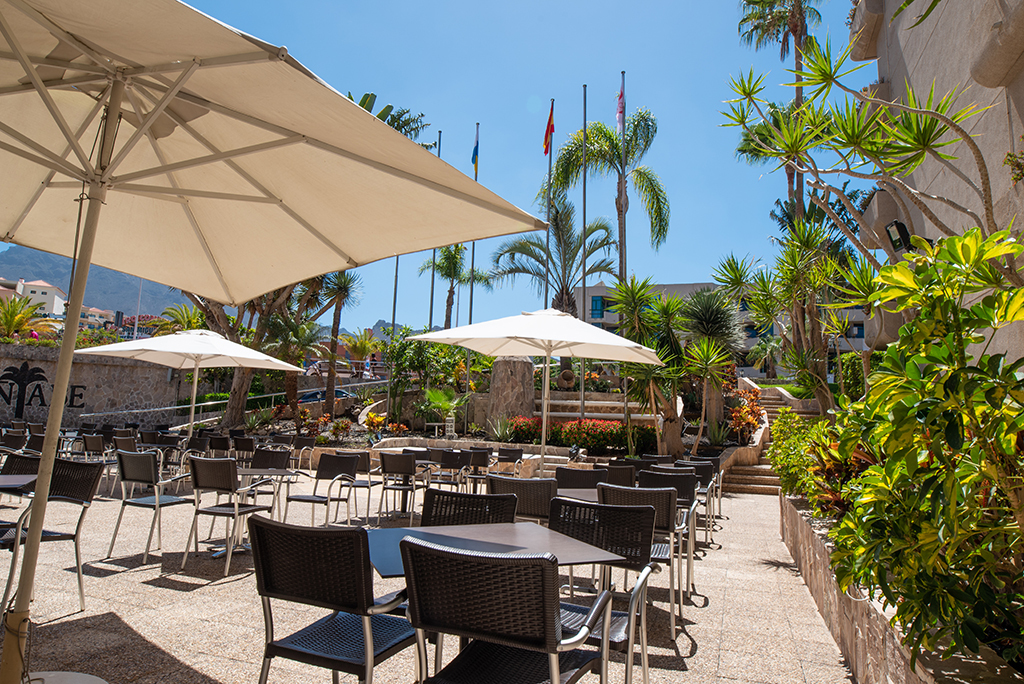 Terras met tafels en parasols omgeven door planten in een restaurant op Tenerife.