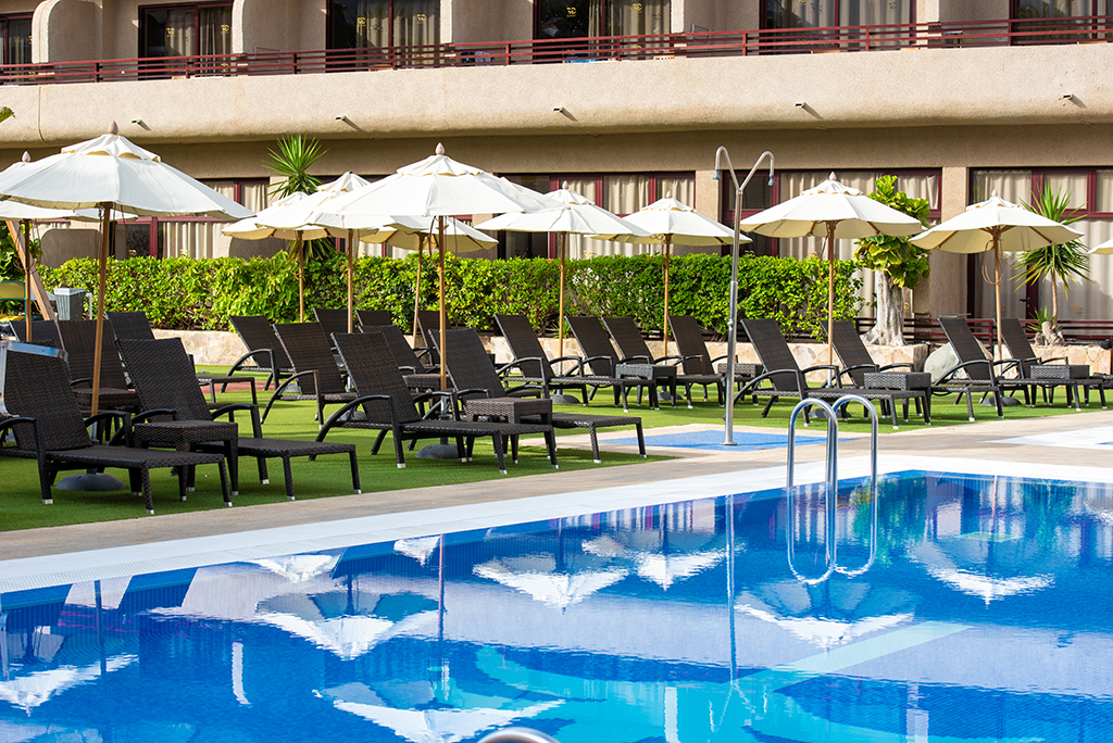 Zwembad en ligstoelen met parasols in een hotel op Tenerife.