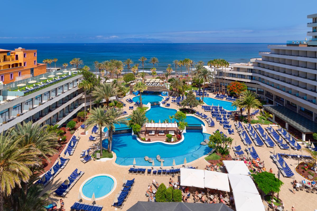 Hotelcomplex met zwembaden en ligstoelen nabij de zee op Tenerife.