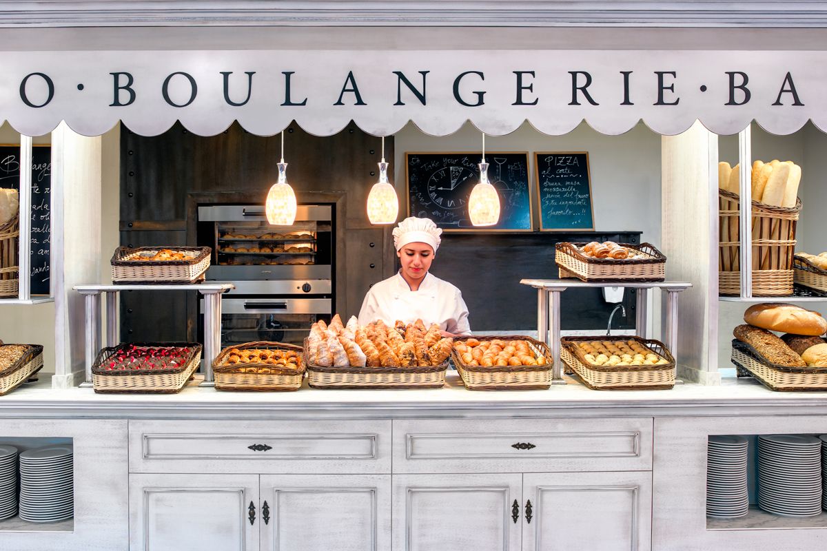 Vrouw in de bakkerij met schalen vol brood en taarten op Tenerife.