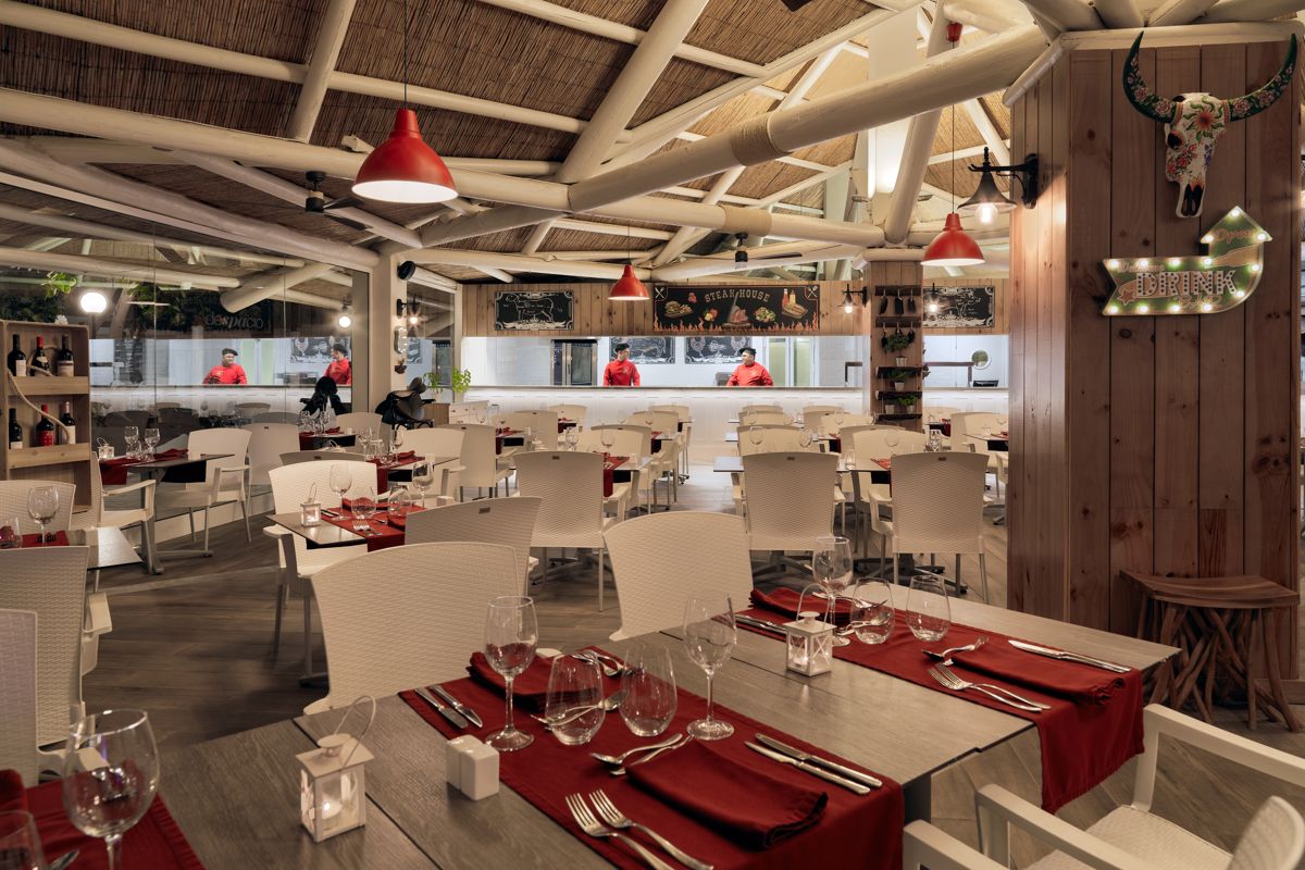 Restaurant op Tenerife met versierde tafels en chefs op de achtergrond in een open keuken.