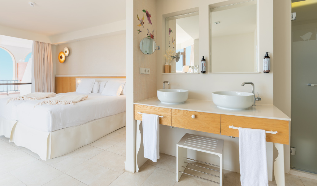 Een lichte kamer met tweepersoonsbed, moderne badkamer en uitzicht op zee op Tenerife.