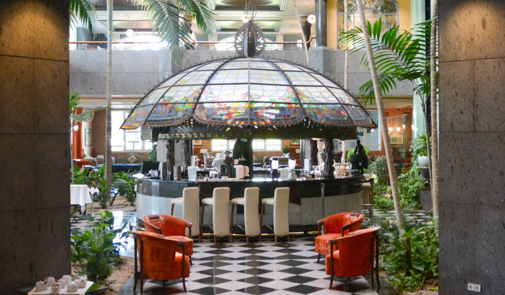 Bar in een hotel op Tenerife met een glas-in-loodkoepel en stoelen eromheen.
