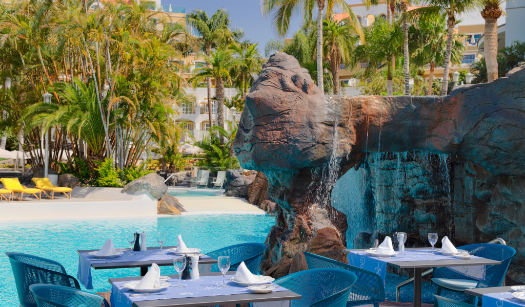 Tafel klaargemaakt naast waterval en zwembad in een hotel op Tenerife.