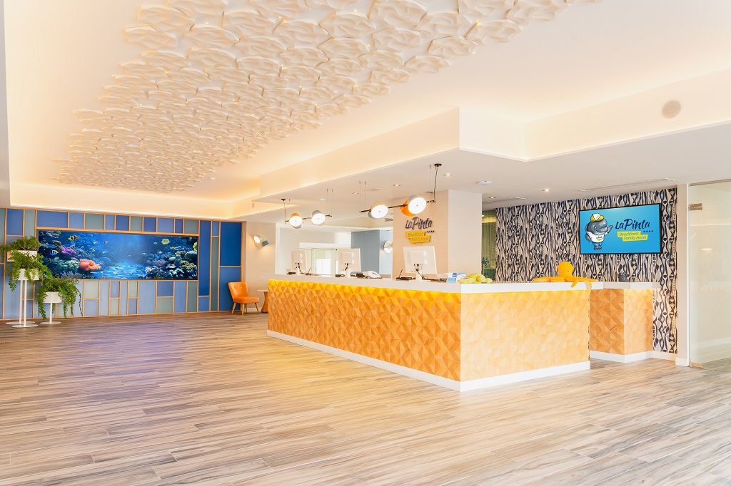 Ontvangst van het La Pinta hotel op Tenerife met aquarium en verlichte balie.