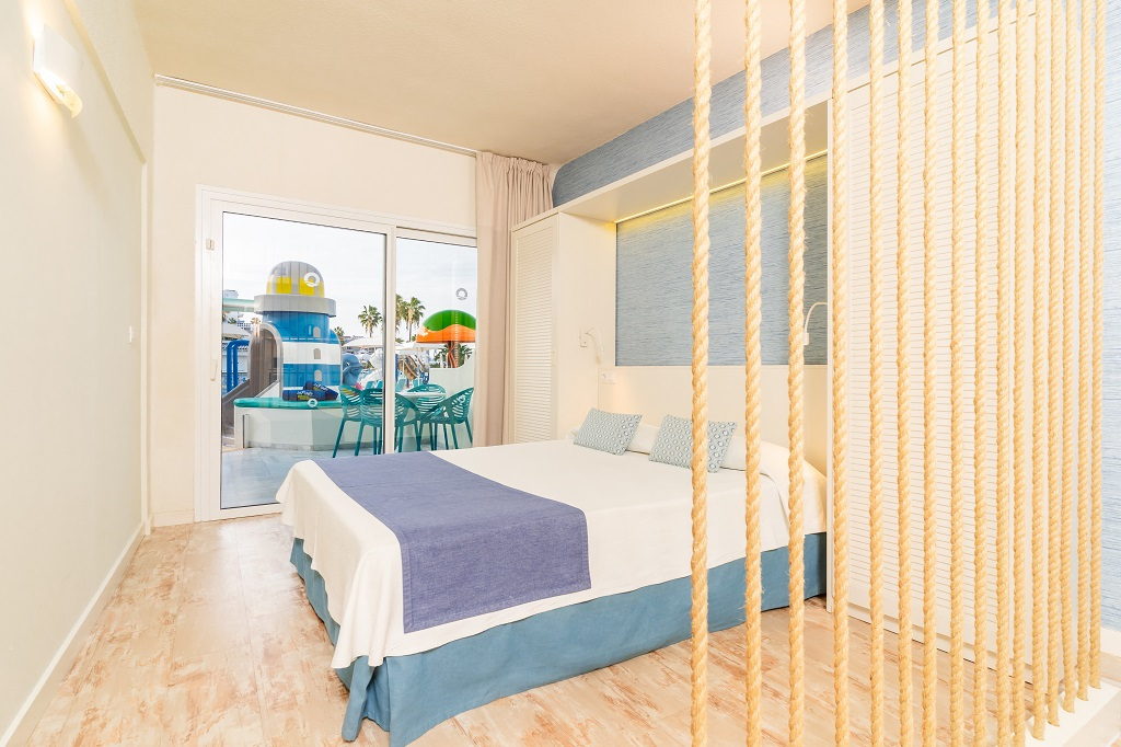 Kamer met tweepersoonsbed en uitzicht op de speeltuin van de kinderen op Tenerife.