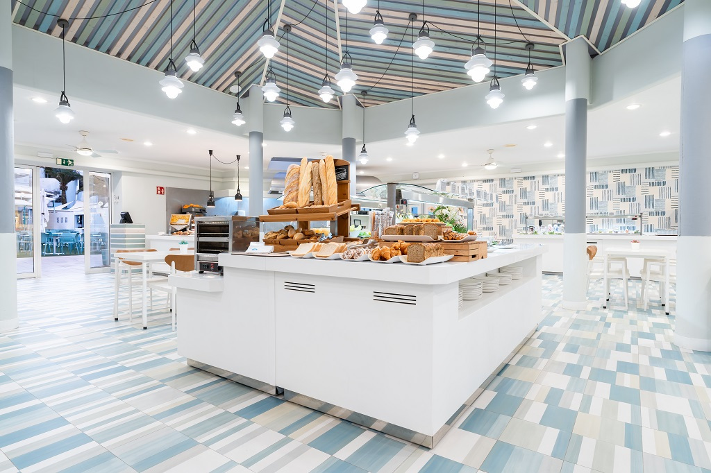 Cafetaria-interieur op Tenerife met planken vol brood en gebak.