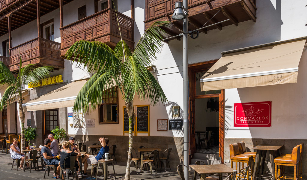 Mensen zitten op een terras voor de Don Carlos-bar op Tenerife.