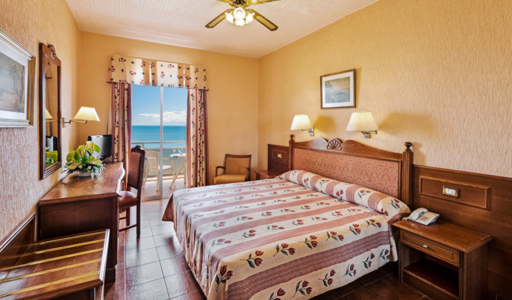 Hotelkamer op Tenerife met tweepersoonsbed en uitzicht op zee vanaf het balkon.