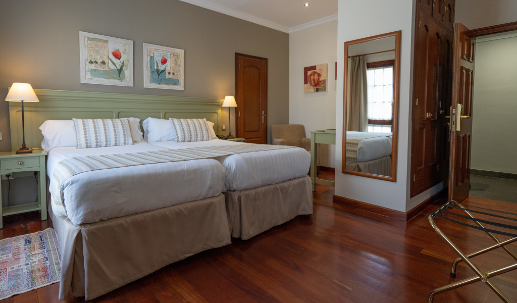 Tweepersoonskamer met groot bed, lampen en spiegel in een hotel op Tenerife.