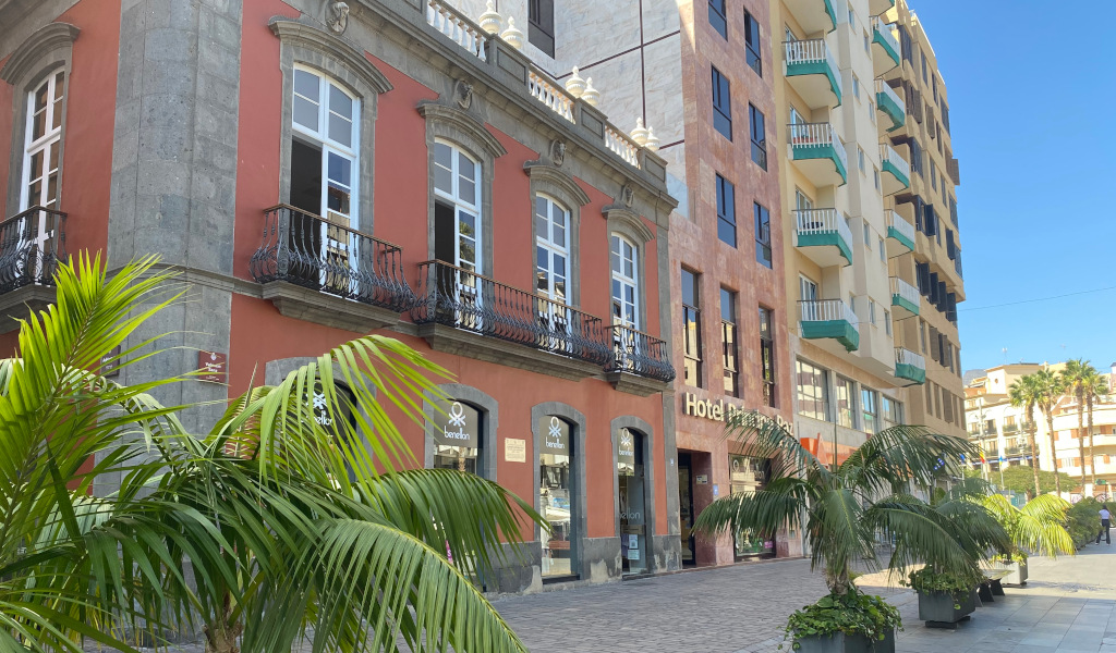 Historisch gebouw naast het hotel in Santa Cruz, Tenerife, met palmbomen ervoor.
