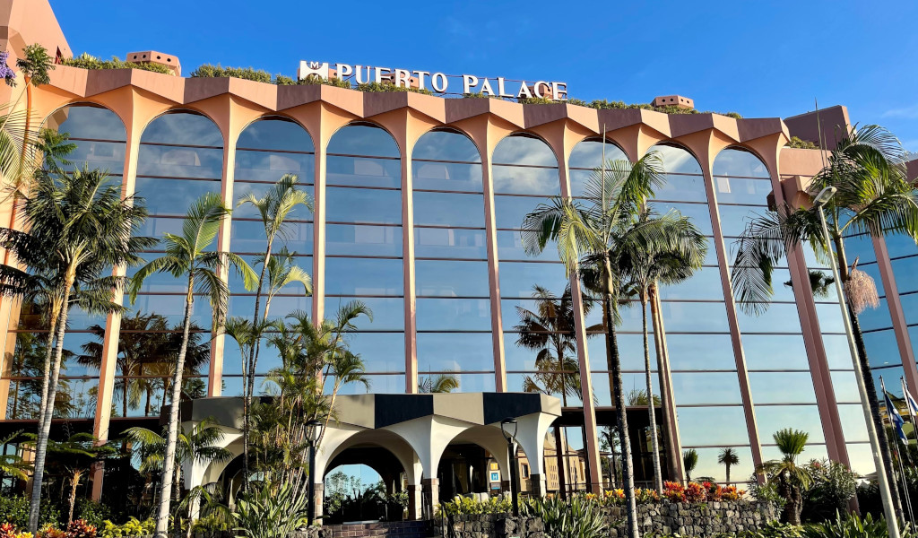 Gevel van het Hotel Puerto Palace op Tenerife met palmbomen ervoor.
