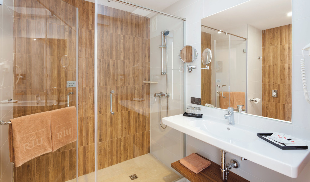 Badkamer van het hotel op Tenerife met douche en wastafel. Hangende handdoeken, Riu-merk.
