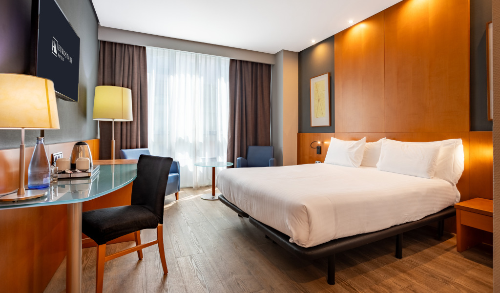 Hotelkamer op Tenerife met tweepersoonsbed, bureau en stoel.