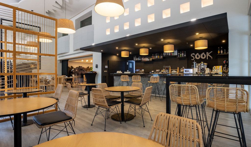 Interieur van de Sook-cafetaria op Tenerife, met rieten tafels en stoelen.