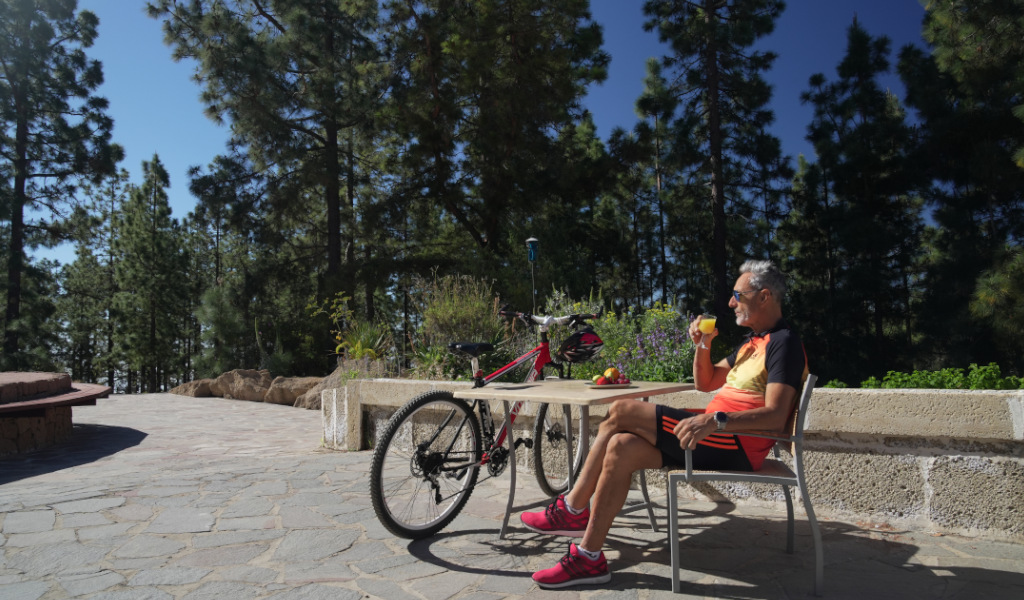 Man met drankje naast fiets in het bos van Tenerife.