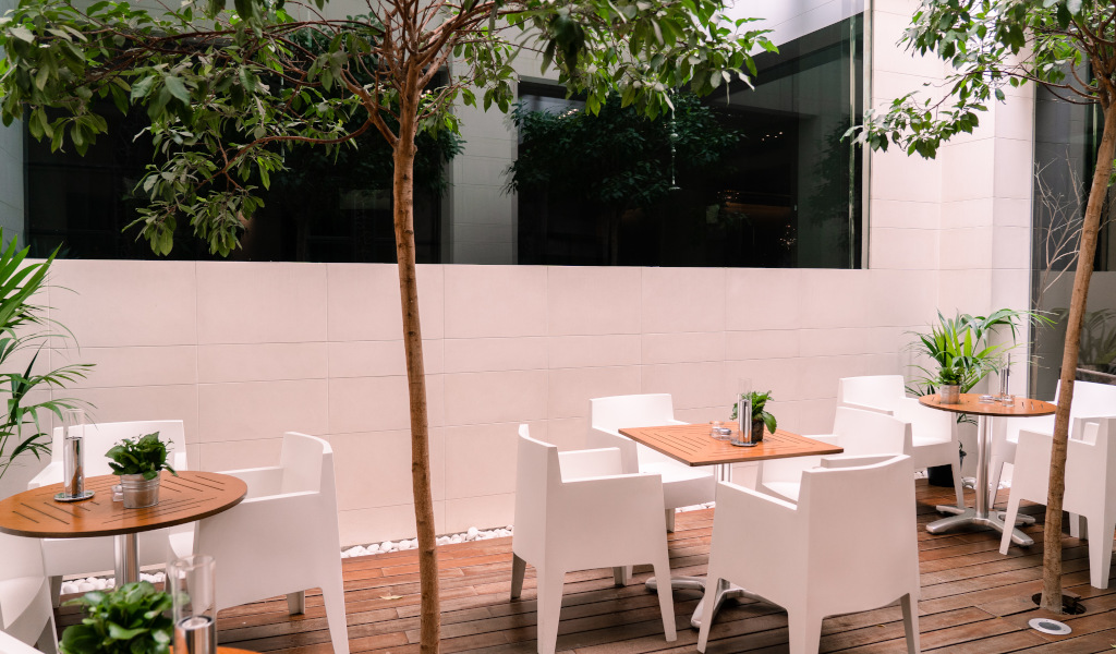 Terras met witte tafels en stoelen, omringd door planten op Tenerife.