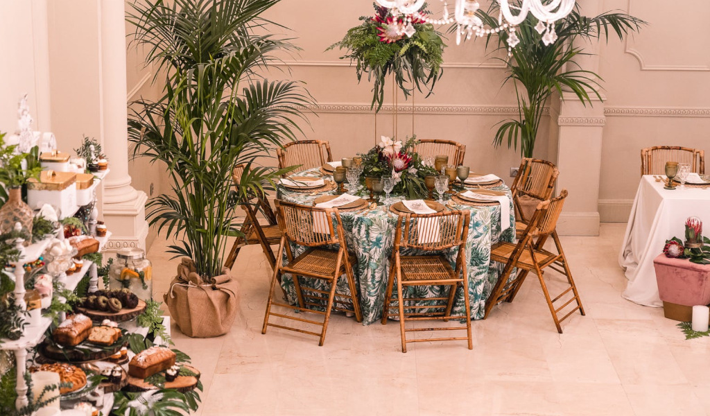 Tafel versierd voor een evenement op Tenerife met houten stoelen en sierplanten.