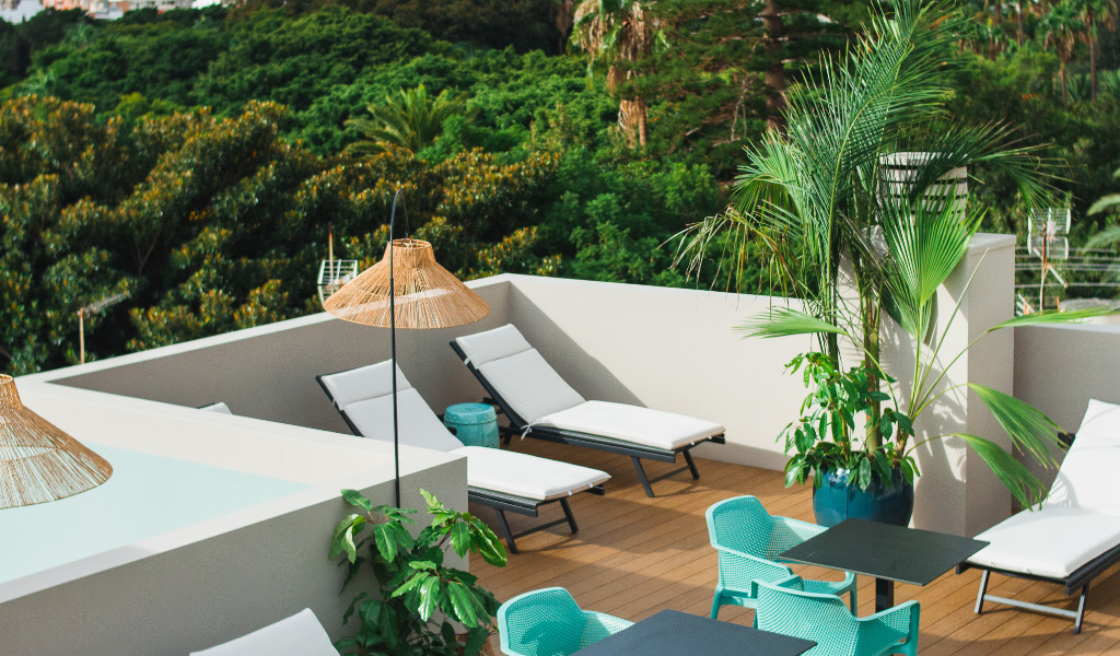 Terras met ligstoelen, parasols, stoelen en planten op Tenerife.