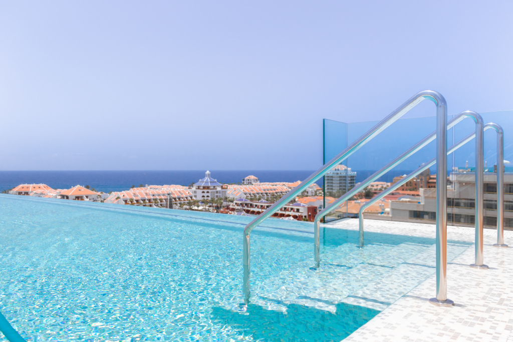 Infinity zwembad met uitzicht op zee en gebouwen op Tenerife.