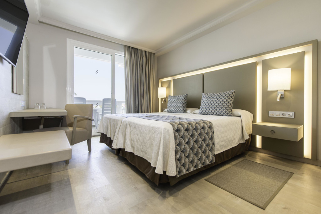 Tweepersoonsbed in een moderne hotelkamer op Tenerife met uitzicht naar buiten.