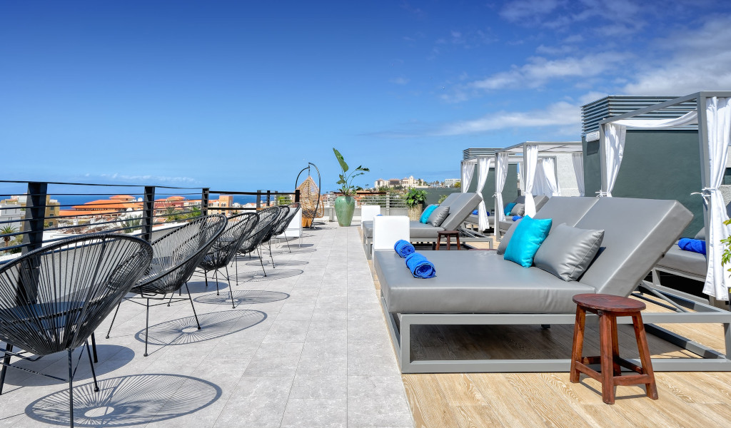 Terras met ligstoelen en uitzicht op zee in een hotel op Tenerife.