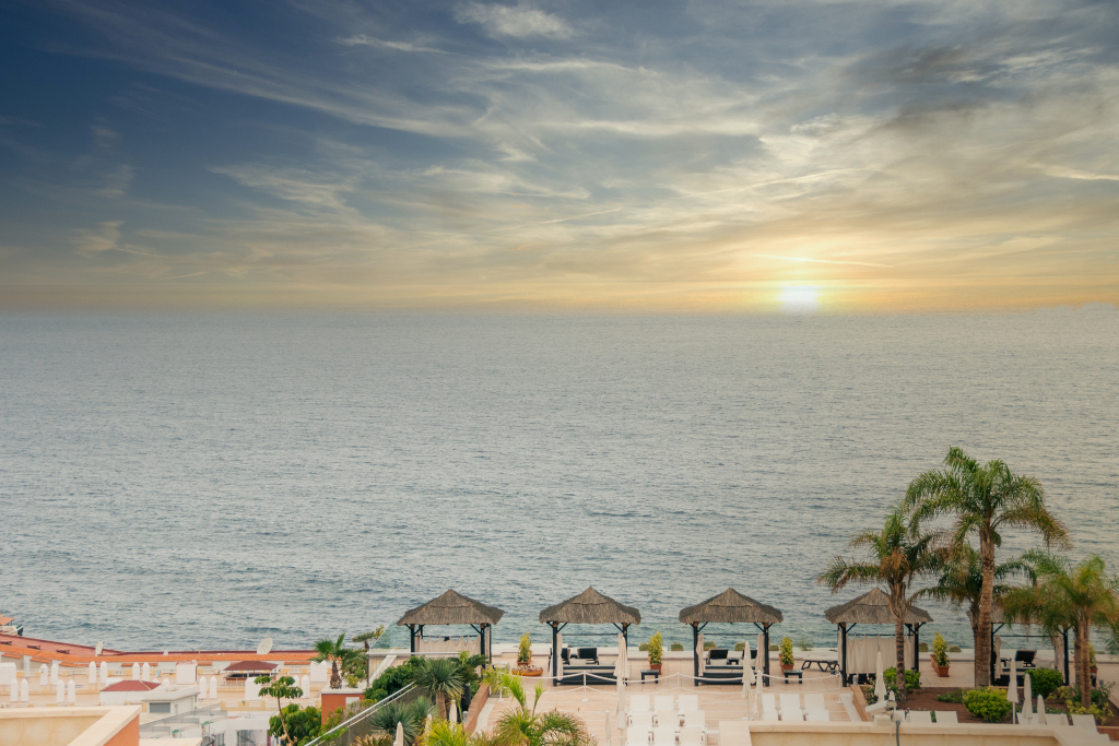 Terras met cabana's aan zee bij zonsondergang op Tenerife.