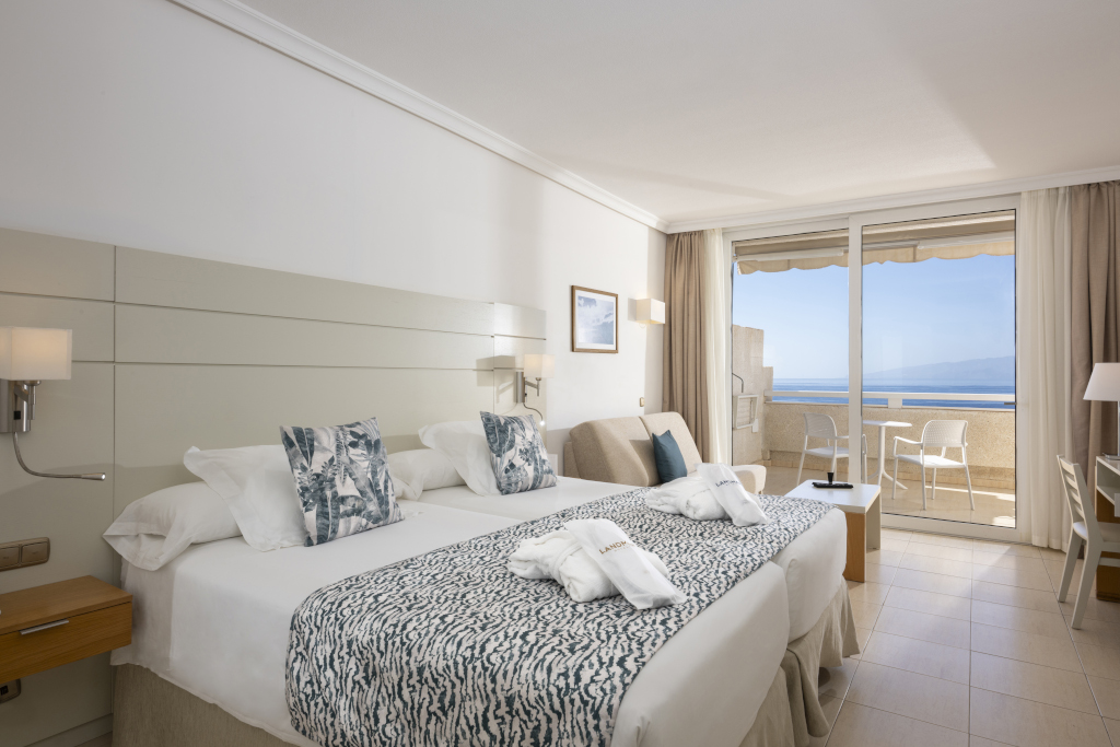 Hotelkamer met zeezicht op Tenerife, met tweepersoonsbed en balkon.