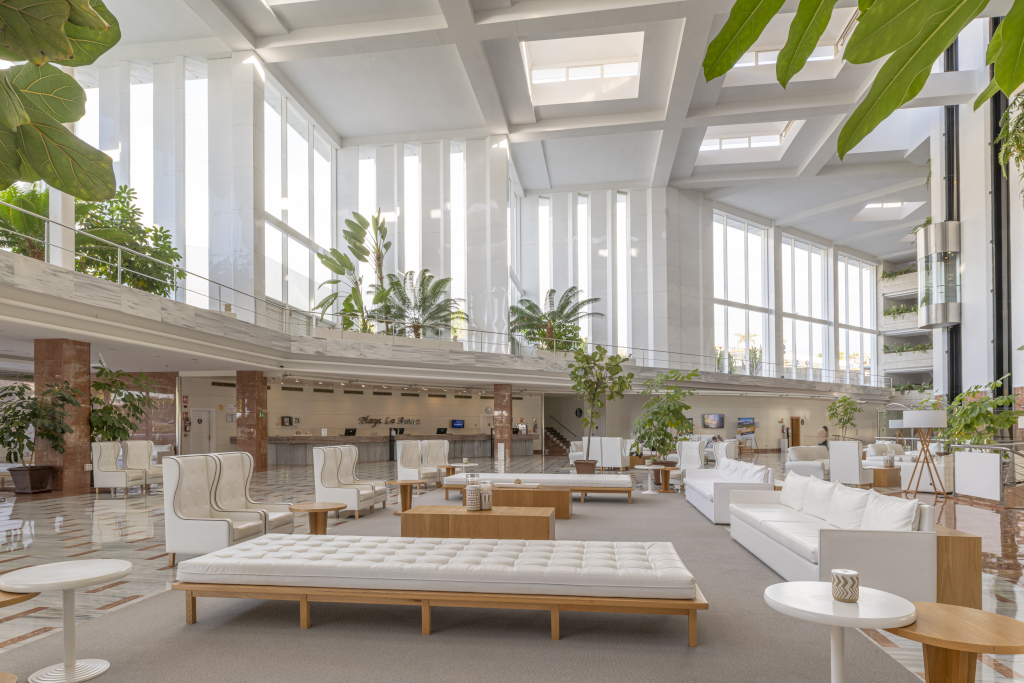 Lobby van het Muga de Beloso hotel op Tenerife, met planten en witte banken.