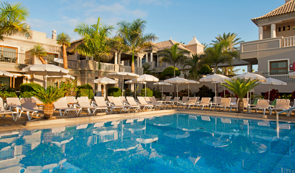 Zwembad omringd door ligstoelen en parasols in een hotel op Tenerife.