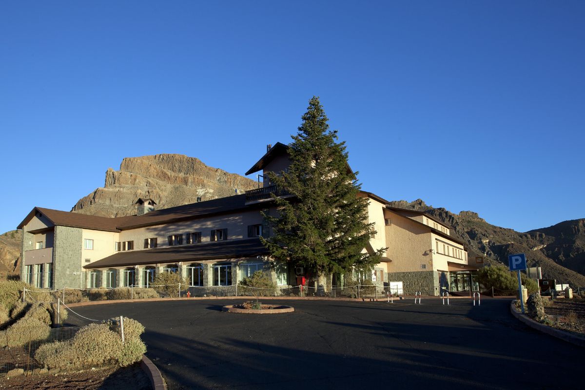 Gebouwen geflankeerd door bomen, bergen op de achtergrond op Tenerife.