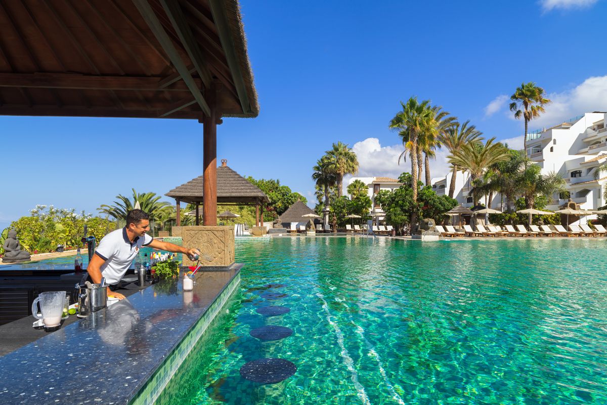 Ober bedient aan de bar van een zwembad op Tenerife.