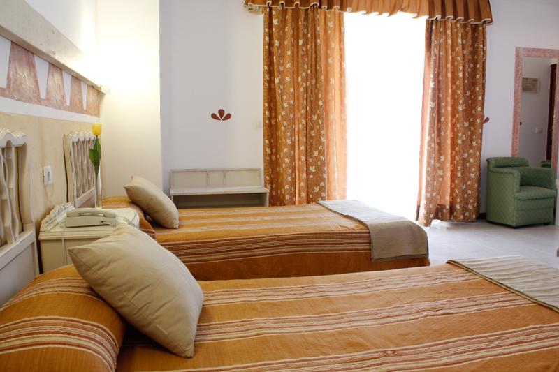 Kamer met twee eenpersoonsbedden en oranje gordijnen in een hotel op Tenerife.