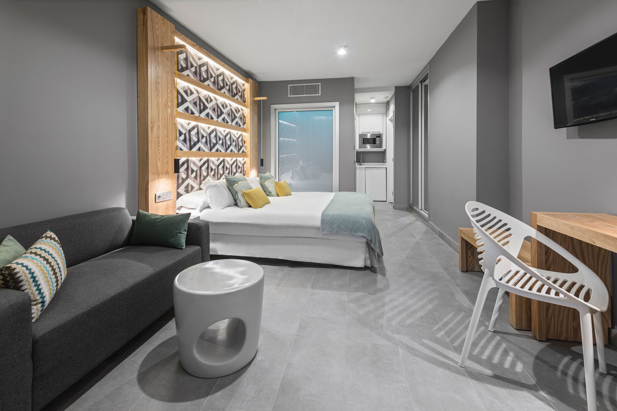 Moderne kamer in een hotel op Tenerife met bed, bank en bureau.