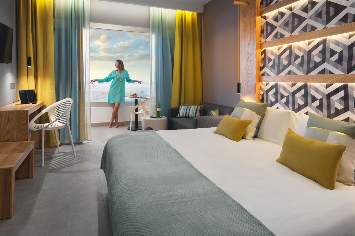 Moderne kamer op Tenerife met uitzicht op zee, vrouw bij het raam.