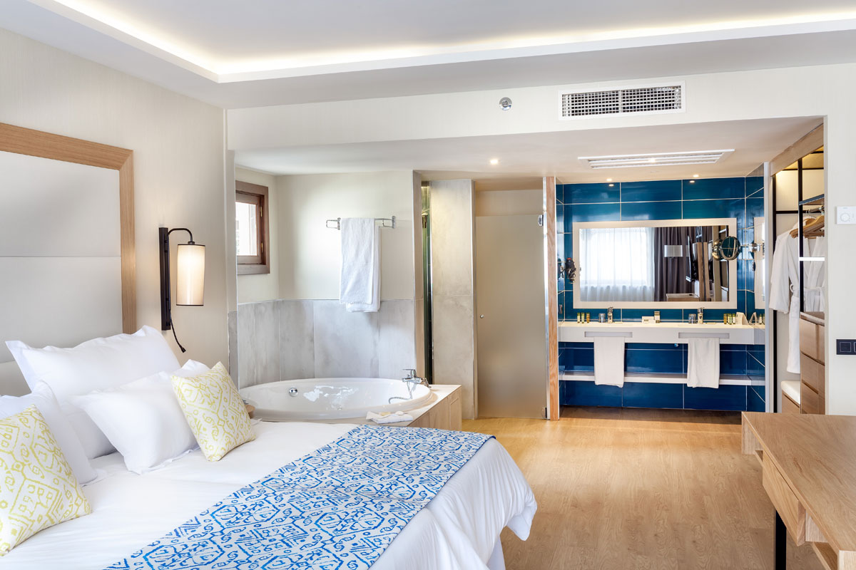 Kamer met tweepersoonsbed en badkamer met jacuzzi in een hotel op Tenerife.