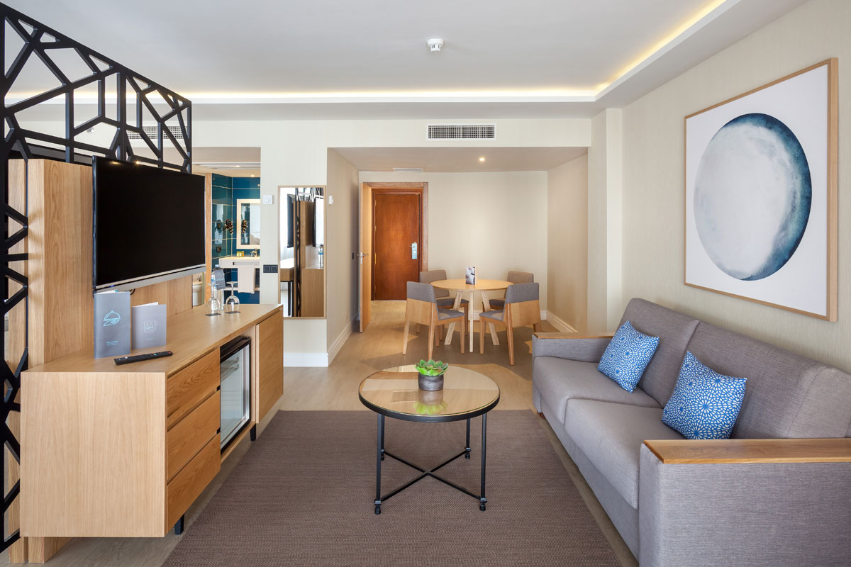Moderne woonkamer in een hotel op Tenerife met bank, tafel en tv.