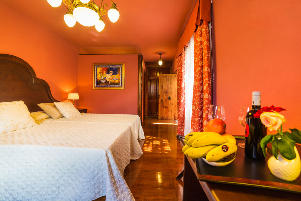 Hotelkamer op Tenerife met tweepersoonsbed en tafel met fruit en wijn.