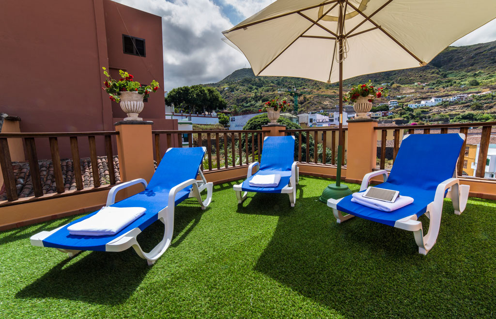 Blauwe ligstoelen met parasol op het terras van Garachico, Tenerife.