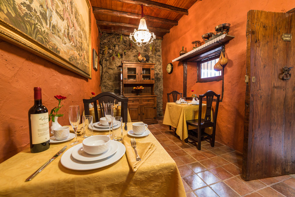 Restauranttafel op Tenerife met borden, glazen en een fles rode wijn.