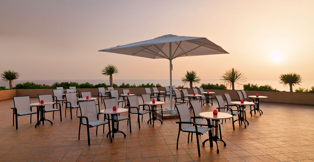 Terras met tafels en stoelen met uitzicht op de zonsondergang op Tenerife.