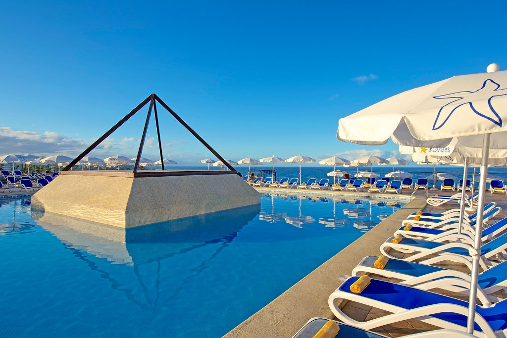 Zwembad met parasols en ligstoelen in een hotelcomplex op Tenerife.