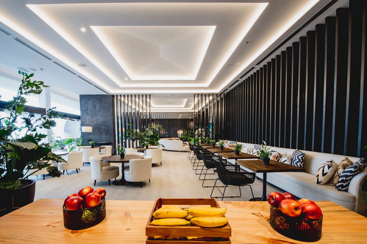 Moderne ruimte met tafels, witte stoelen, planten en fruit op Tenerife.