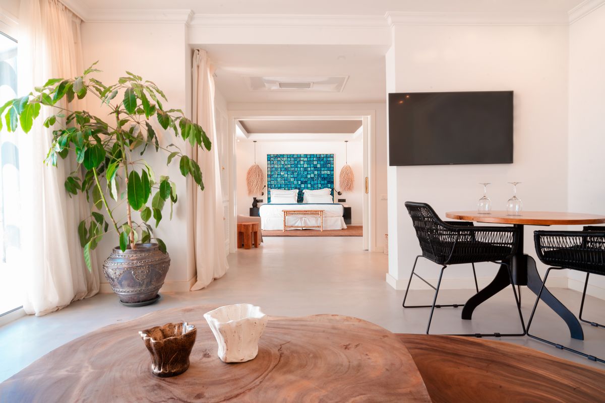 Interieur van een suite met een tweepersoonsbed, tafel met drankjes en plant op Tenerife.