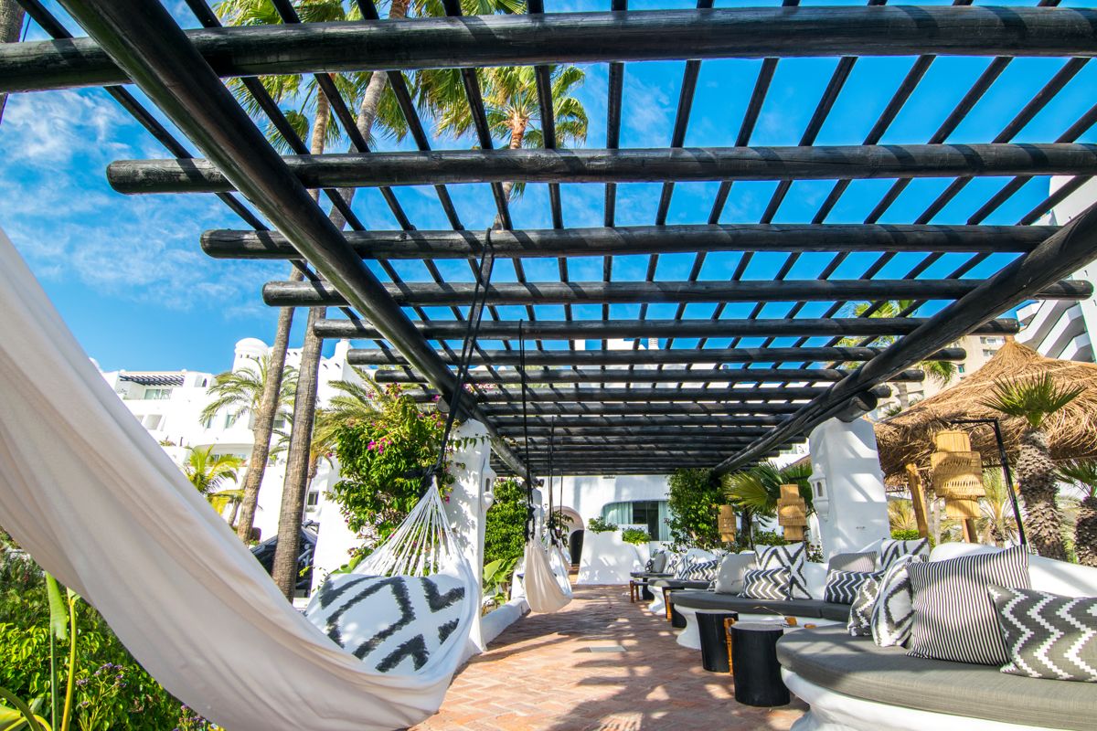 Terras met hangmatten en banken onder een pergola in een complex op Tenerife.